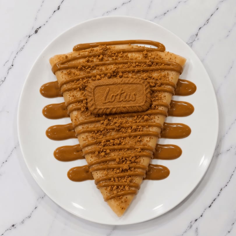 A Lotus Biscoff crepe, drizzled with sauce and topped with crumbs and a cookie.